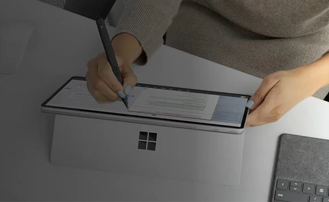 در این عکس یک زن در حال کار با قلم بر روی  تبلت سرفیس پرو ۹ نمایش داده شده است.