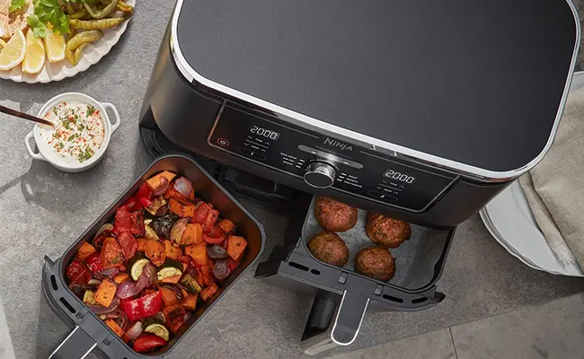 در این عکس یک سرخ کن نینجا af400 با کشوهای باز و غذاهای متفاوت در هر سبد نمایش داده شده است.