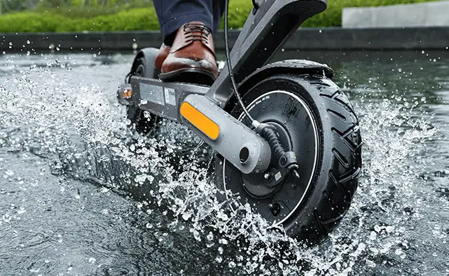 در این عکس اسکوتر برقی شیائومی mi electric scooter 4 ultra در حال حرکت در آب نمایش داده شده است.