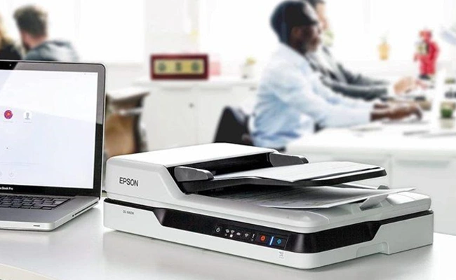 اسکنر اپسون DS-1630 اسکنر اپسون DS-1630 قرار گرفته روی میز در کنار لپ تاپ