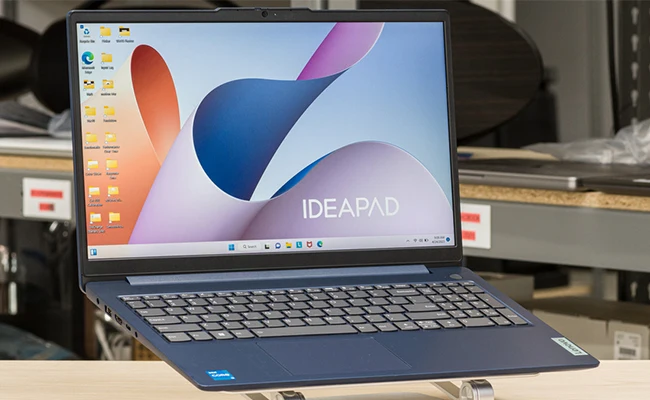 تصویر لپ‌تاپ Lenovo IdeaPad Slim 3  روی کول پدی قرار گرفته روی میز